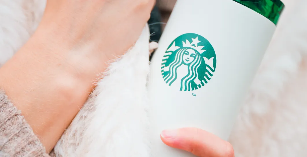 člověk držící bílý tumbler Starbucks